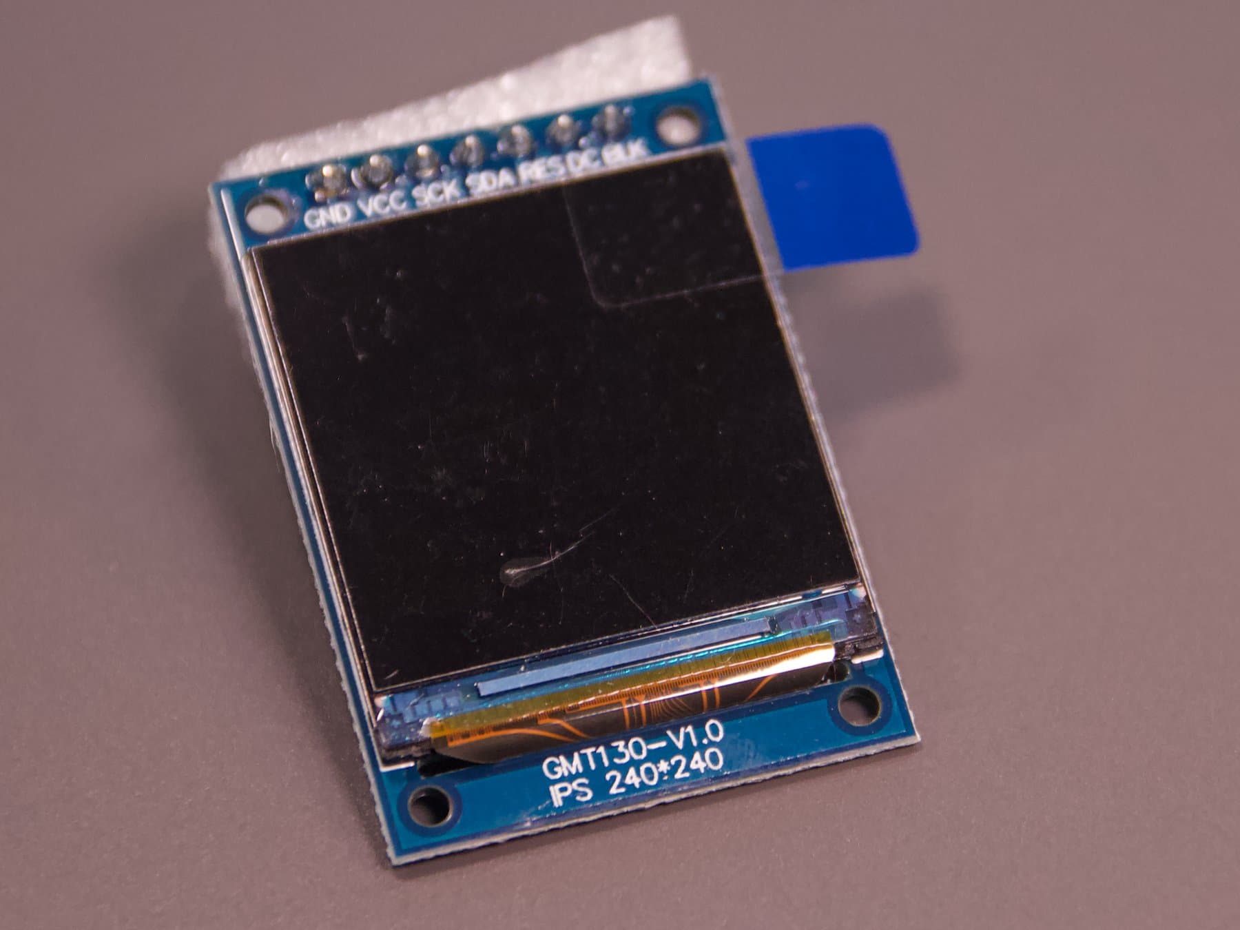 Vorderseite des quadratischen GMT130-V1.0-Displays mit schwarzer Anzeigefläche und sieben Anschlüssen.